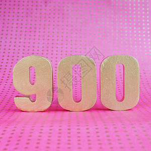 在明亮粉红圆点背景的900号金体积图片