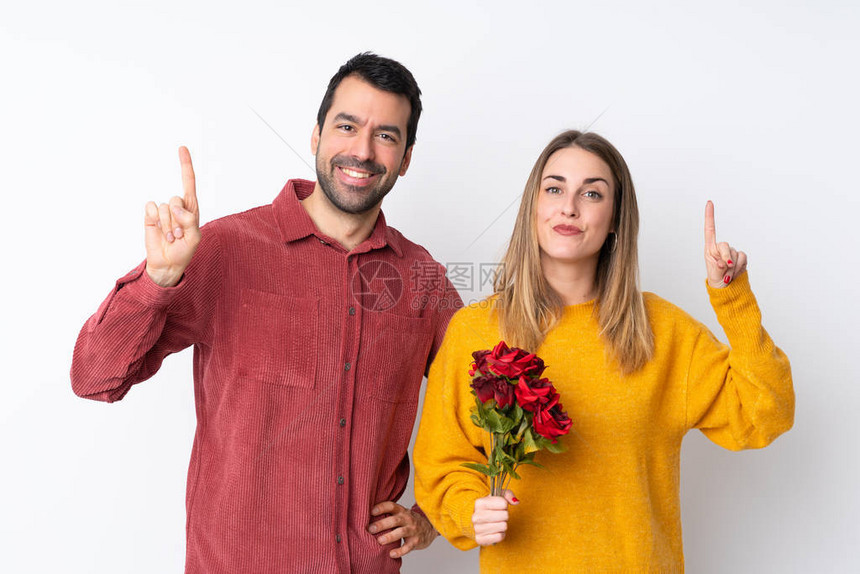 情人节的一对情侣拿着鲜花在孤立的背景下展示并举起一只手指作图片