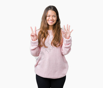 年轻漂亮的黑发女人穿着粉红色的冬季毛衣图片