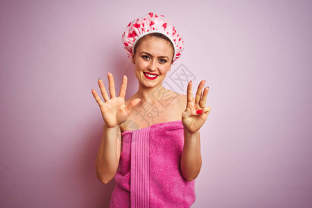 年轻漂亮的女人在淋浴后戴着毛巾和浴帽图片
