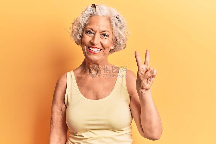 身着便衣的高级灰色头发妇女带着双指头举起手来图片