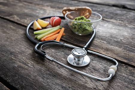 健康的生活方式概念形象听诊器围绕自制面包鳄梨酱和新鲜生蔬菜的健康素食图片