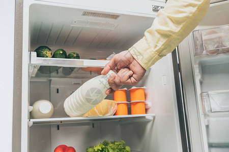 人类在冰箱里放瓶装牛奶以及架子上新鲜食图片
