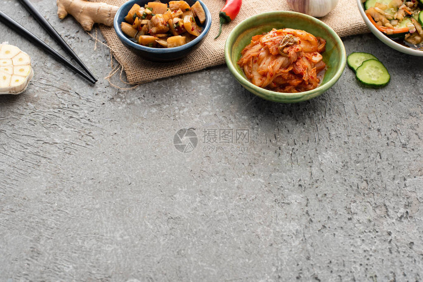 鱼叉姜辣椒切片黄瓜和混凝土表面大蒜的碗图片