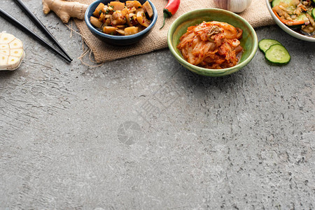 鱼叉姜辣椒切片黄瓜和混凝土表面大蒜的碗图片