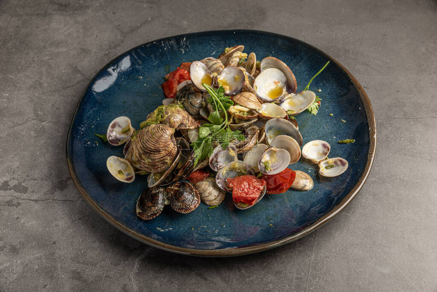 剩菜盘的空壳蛤蜊西葫芦西红柿西葫芦和欧芹意大利食谱意图片