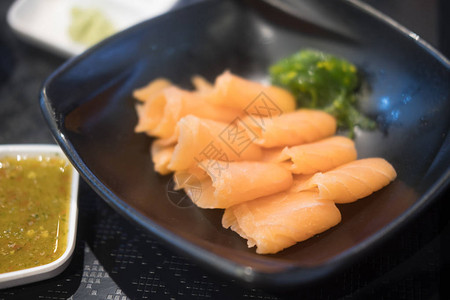 黑盘上的鲑鱼生片或生鲑鱼背景图片
