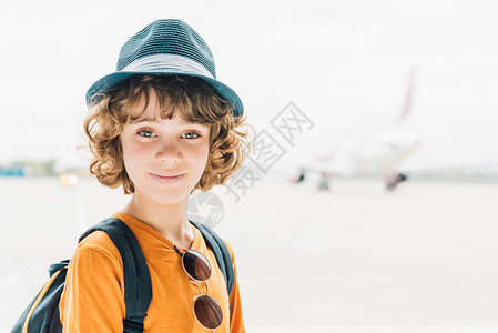 戴着帽子的可爱小孩在机场用复印图片