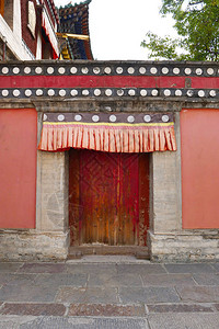 青海省西宁市湟中县藏传佛教寺院塔尔寺库姆寺的复古木门和墙壁背景