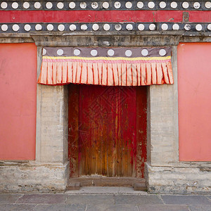 青海省西宁市湟中县藏传佛教寺院塔尔寺库姆寺的复古木门和墙壁图片