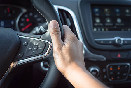 特写亚洲男手拿着现代汽车方向盘与音频控制按钮语音和电话按钮可用于免提拨图片