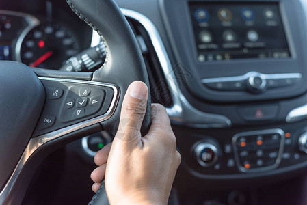 特写亚洲男手拿着现代汽车方向盘与音频控制按钮语音和电话按钮可用于免提拨图片