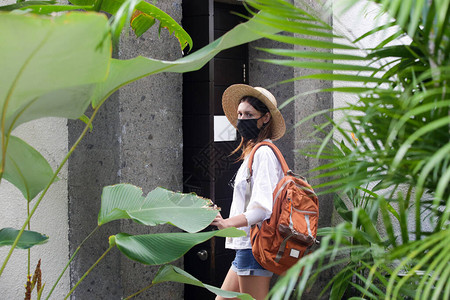 戴着防护面罩的旅游妇女暑假时戴着草帽医用口罩和背包的女人冠状爆图片