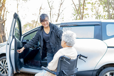 帮助和支持坐在轮椅上的亚洲老年或老年妇人患者准备上车图片