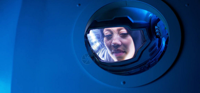 一名女宇航员中镜头她从宇宙飞船背景图片