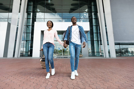 兴奋的黑人夫妇离开新机场大楼图片