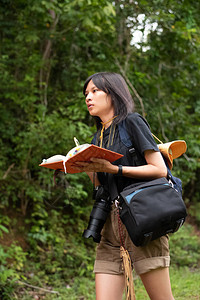 年轻的少年背包和手持书本在公园行走放图片