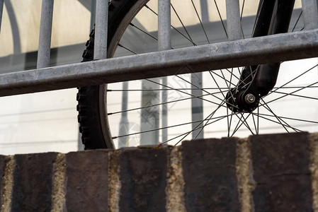 有栏杆的停放的通勤自行车通过栏杆可以看到单循图片