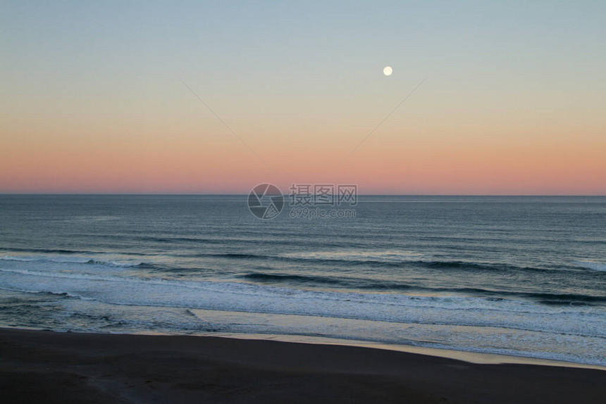 月亮在太平洋海岸的月亮下落太阳给地平线增加一点颜色时图片