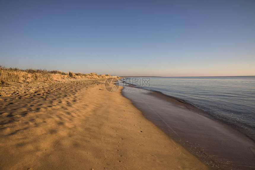 日落时在沙滩上欣赏沙滩和宁静的大海图片