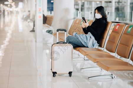 共克疫情衣着面罩的亚洲女游客在科罗纳爆发或共食19次疫情爆发期间坐在社会悬位椅上背景