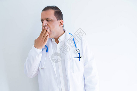 中年医生男子戴着听诊器和白色背景的医用外套图片