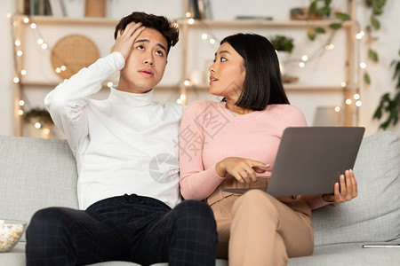 亚洲购物狂妻子与震惊的丈夫在网上购物图片