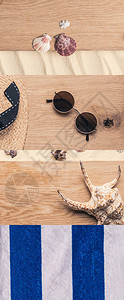 条纹毛巾太阳眼镜草帽木制和沙土背景的贝图片