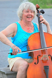 在大提琴外面的街上表演独奏的图片