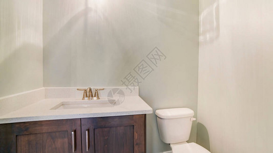 Panorama框架Sink和水龙头在浴室厕所旁的木制柜子上方白色顶部在白内墙上也可以看到亮图片