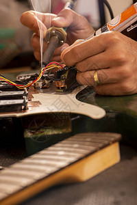 制琴师在他的工作室焊接吉他线图片