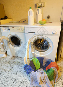 两台洗衣机和衣服用于洗涤房屋阁楼的图片