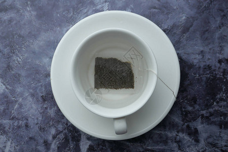 黑石桌上陶瓷杯热水茶包图片