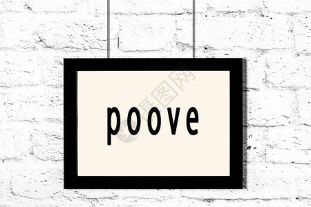 白砖墙上挂着题字poove的黑色木框图片