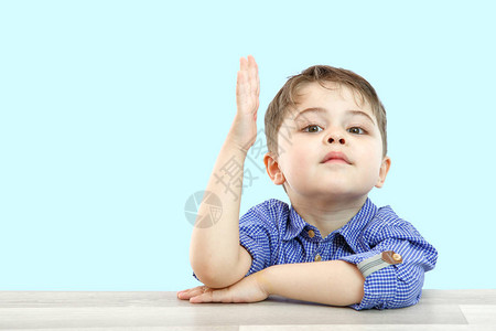 学龄前小男孩举起手回答问题或提问图片