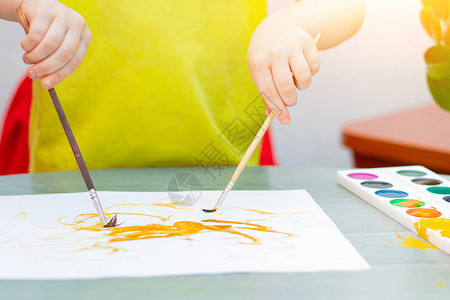 男孩用颜料画坐在家里远程培训儿童教育课程关于儿童休闲的文章家庭图片