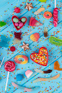 蓝色木桌上的不同甜糖果彩色木制背景顶视图上的各种五彩糖果垃图片