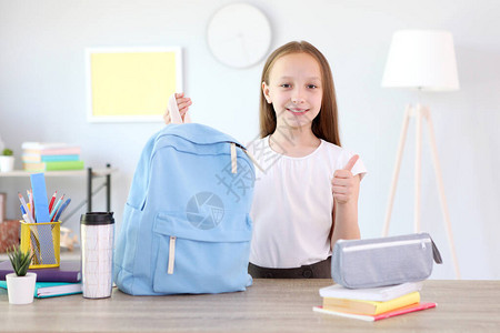 可爱开朗的女学生把文具放在背包里为上学做准备回到学校图片