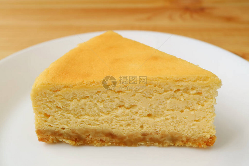白盘上的自制奶油黄色素烤芝士蛋糕片图片