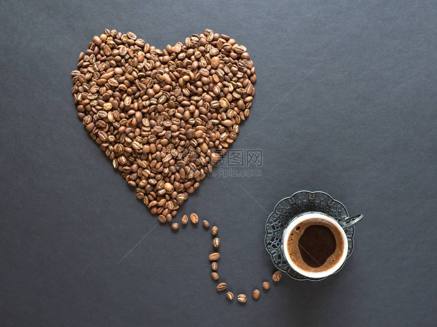 心形由咖啡豆和一杯黑咖啡制成图片