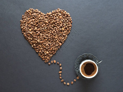 心形由咖啡豆和一杯黑咖啡制成图片