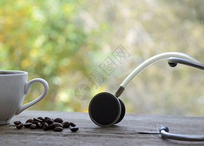 一杯咖啡旁边躺着一粒咖啡和一个听诊器概念咖啡图片