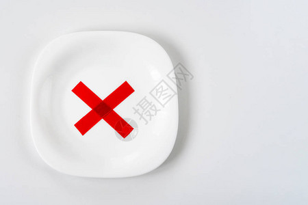白桌上有红色X十字标记的白色盘图片