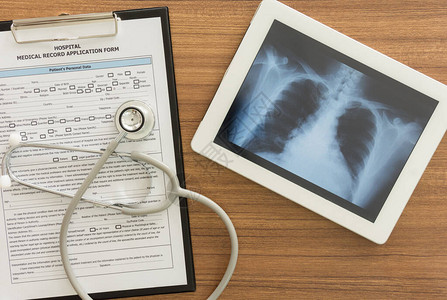 平板电脑听诊器医生桌上的医疗文件的X射线肺部图象最高视图片