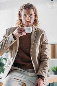 高雅的时尚商人在办公室喝咖啡在图片