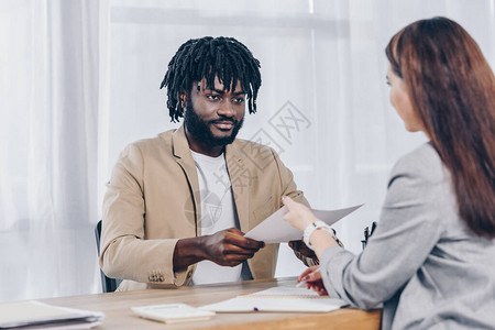 有选择地关注非裔美国雇员在办公室面试时向招聘人员提供文件的图片