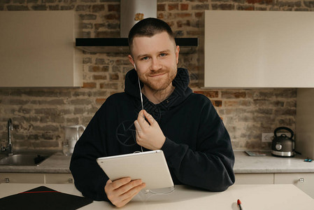 远程在线学习一个留着胡子的男人在他的平板电脑上远程学习一个快乐的家伙图片