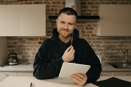 远程在线一个留着胡子的男人在他的平板电脑上远程一个快乐的家伙图片
