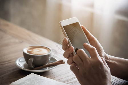在咖啡店喝咖啡和看书时使用手机的人图片