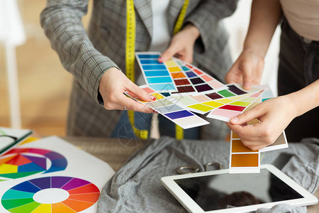 时装设计师在餐桌上选择彩色样本与客图片